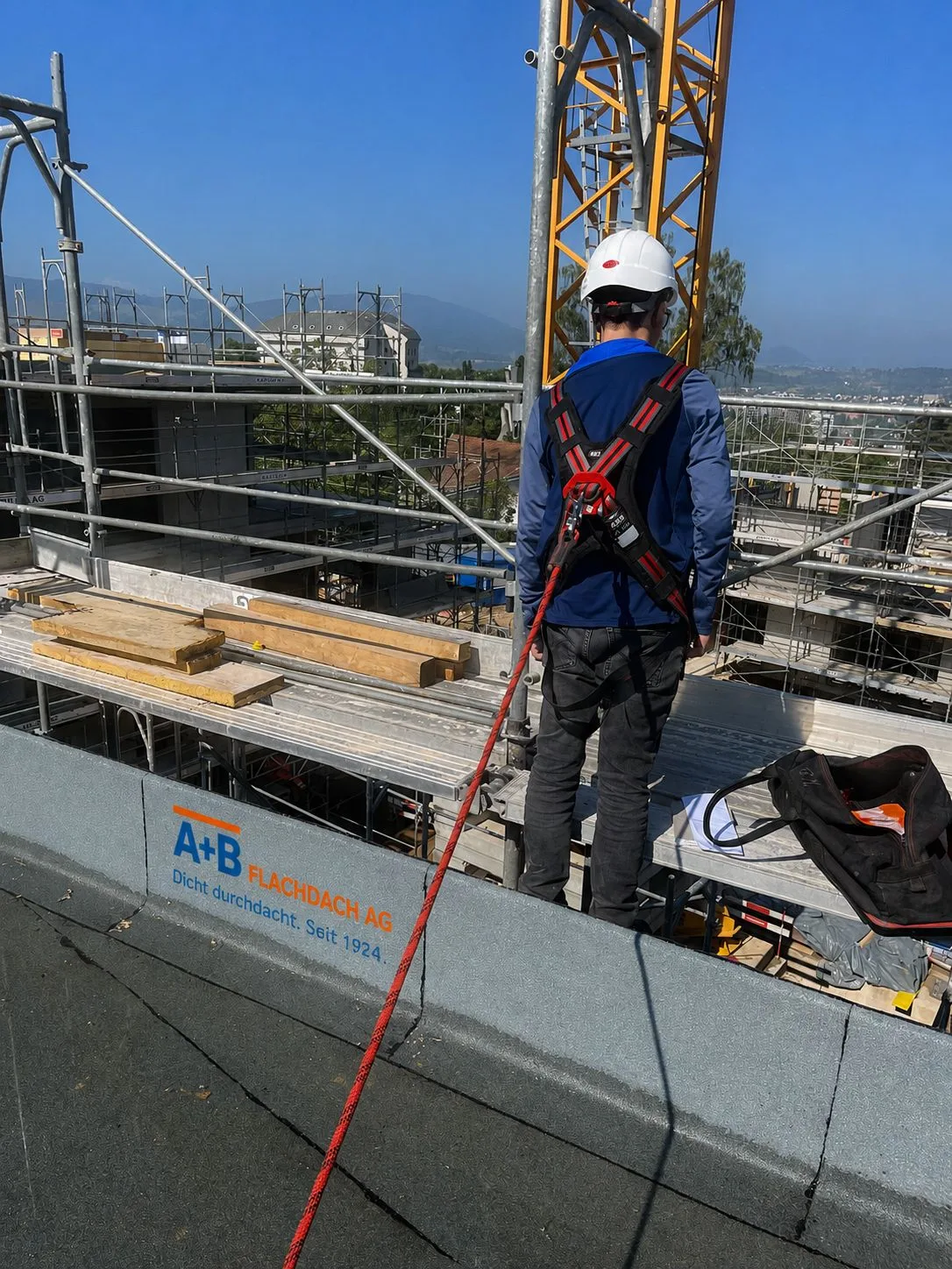 Mitarbeiter von A+B Flachdach mit Höhensicherung auf einer Baustelle